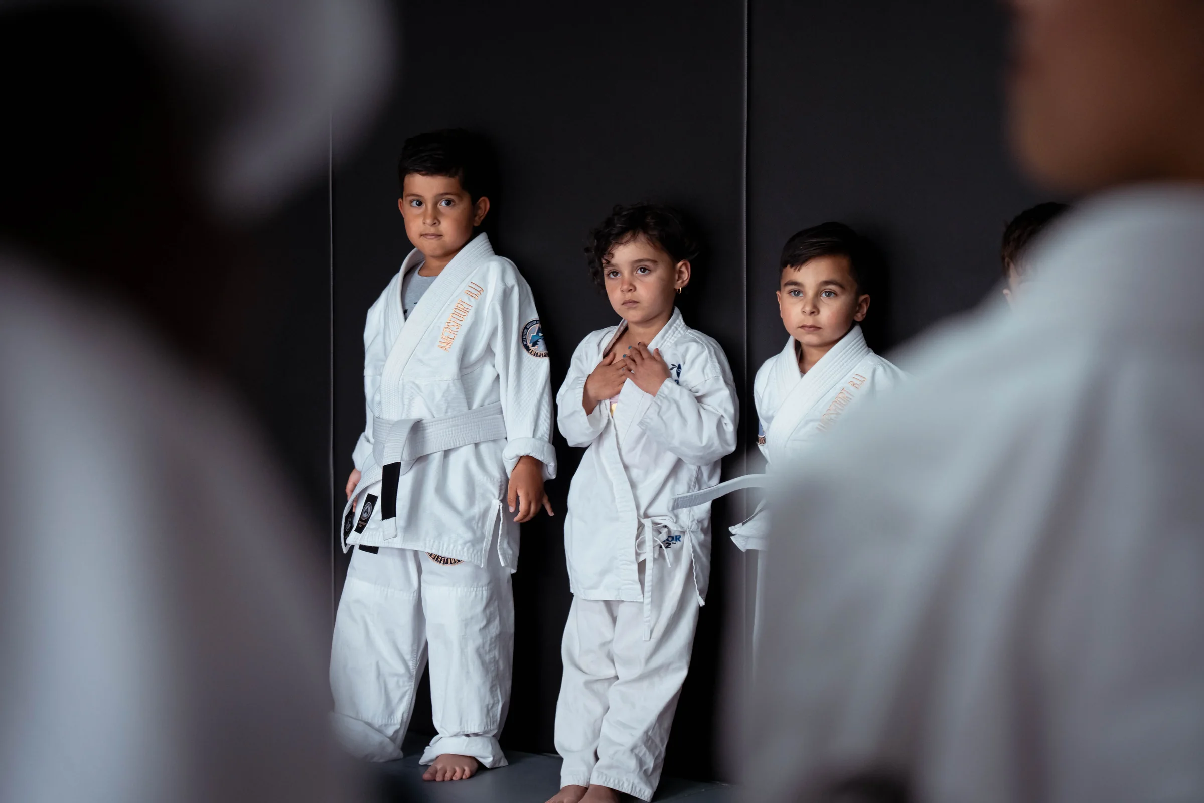 Kinderen kijken toe terwijl de trainer een techniek demonstreert
