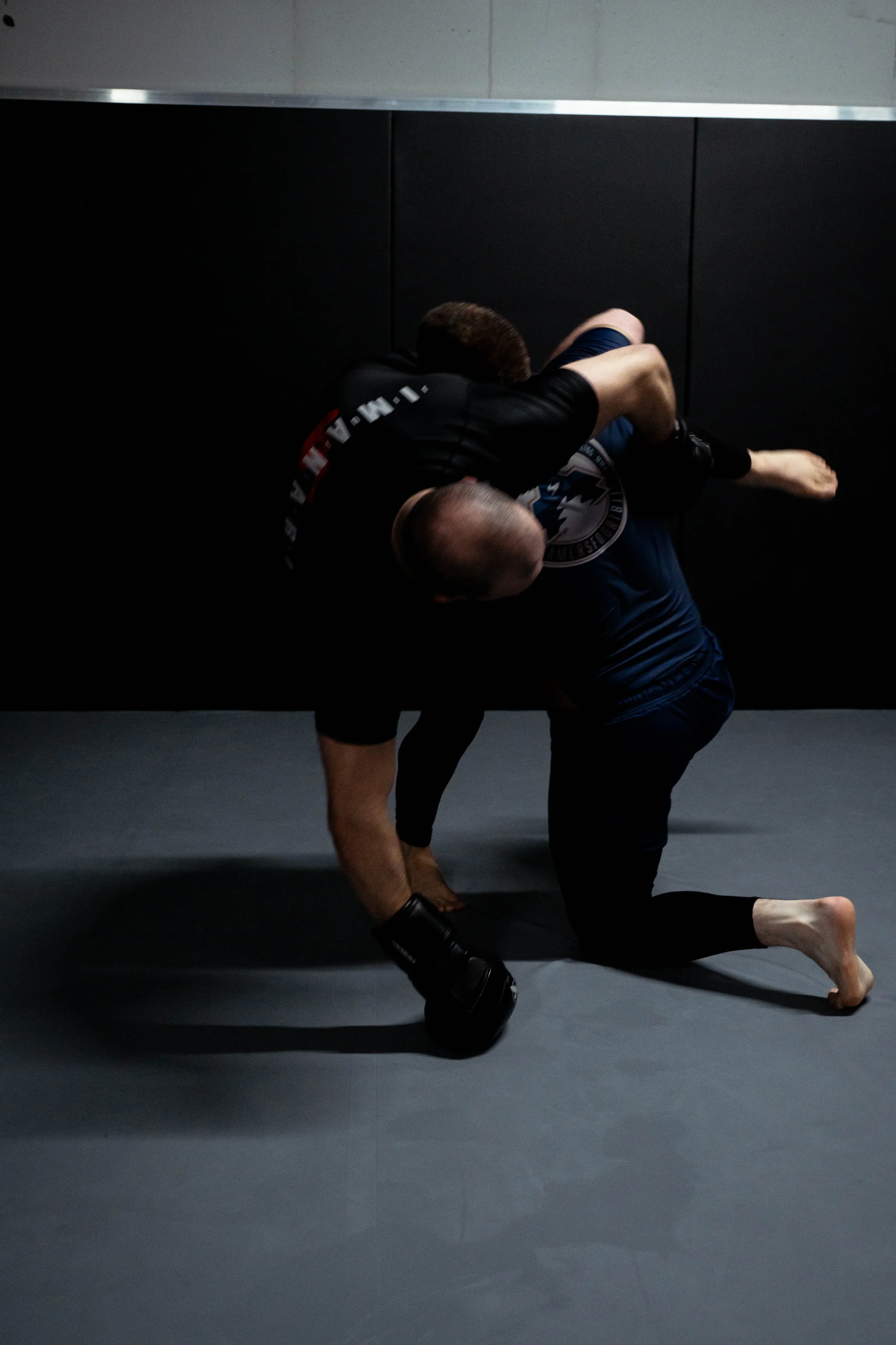 Volwassenen maken een worp tijdens een grappling- en worsteltraining