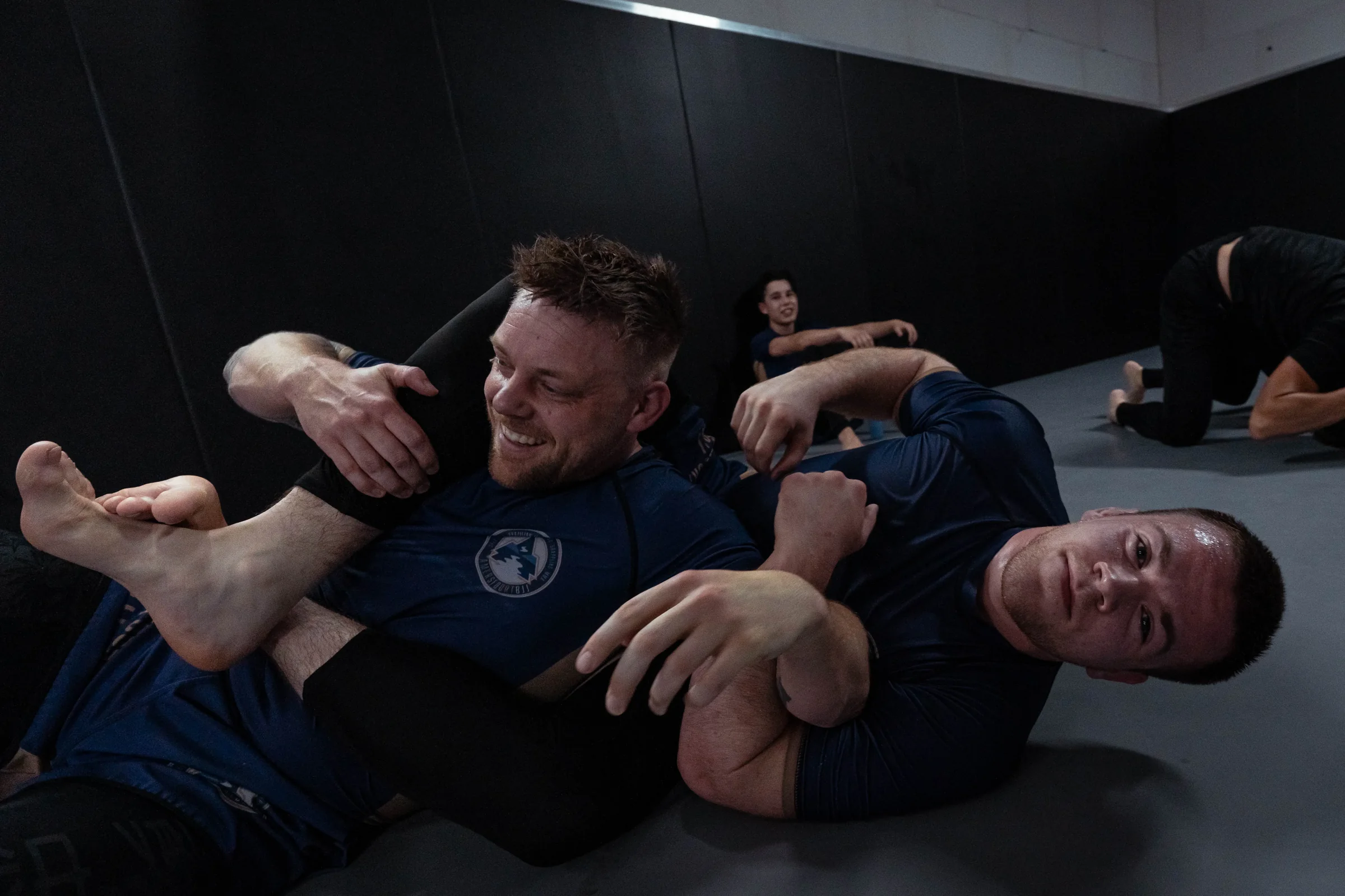 Volwassen BJJ-er werkt vanuit zijn guard in de gi tijdens de les