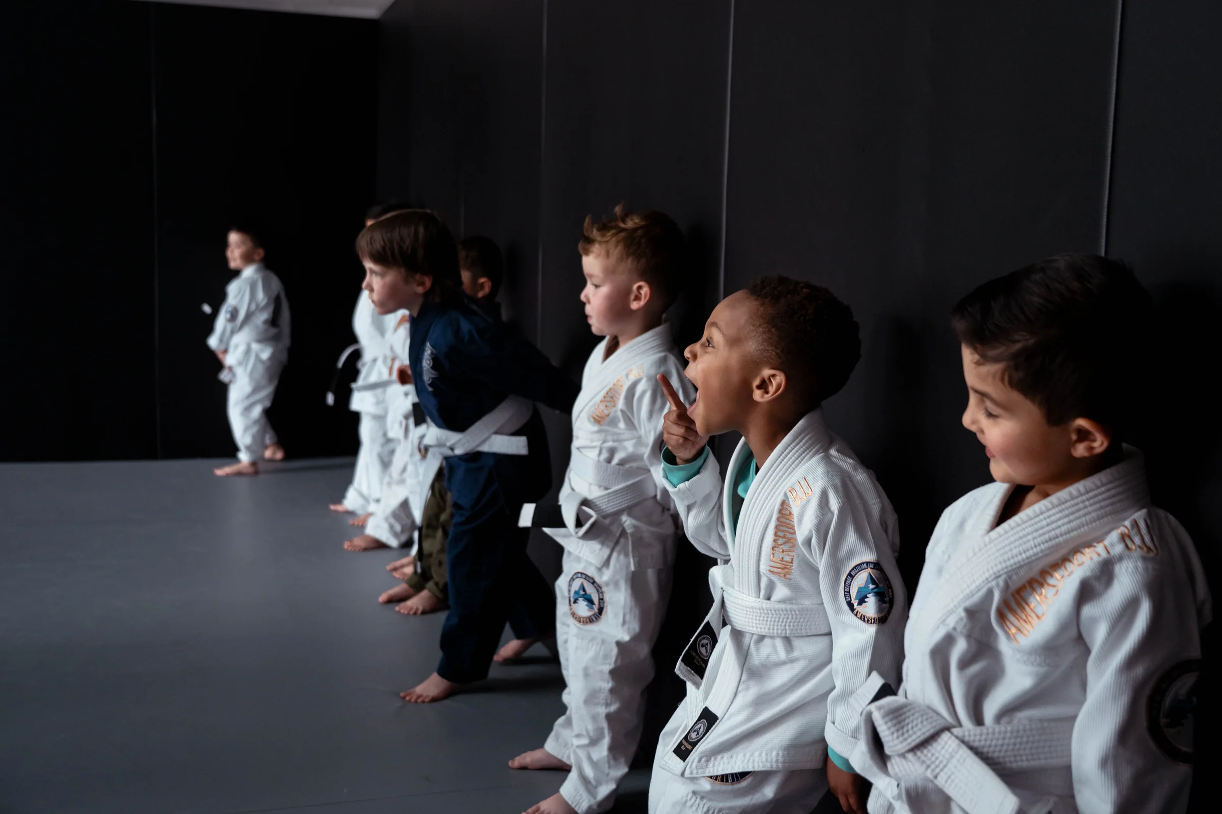 Kinderen staan in een rij op de mat aan het begin van de les