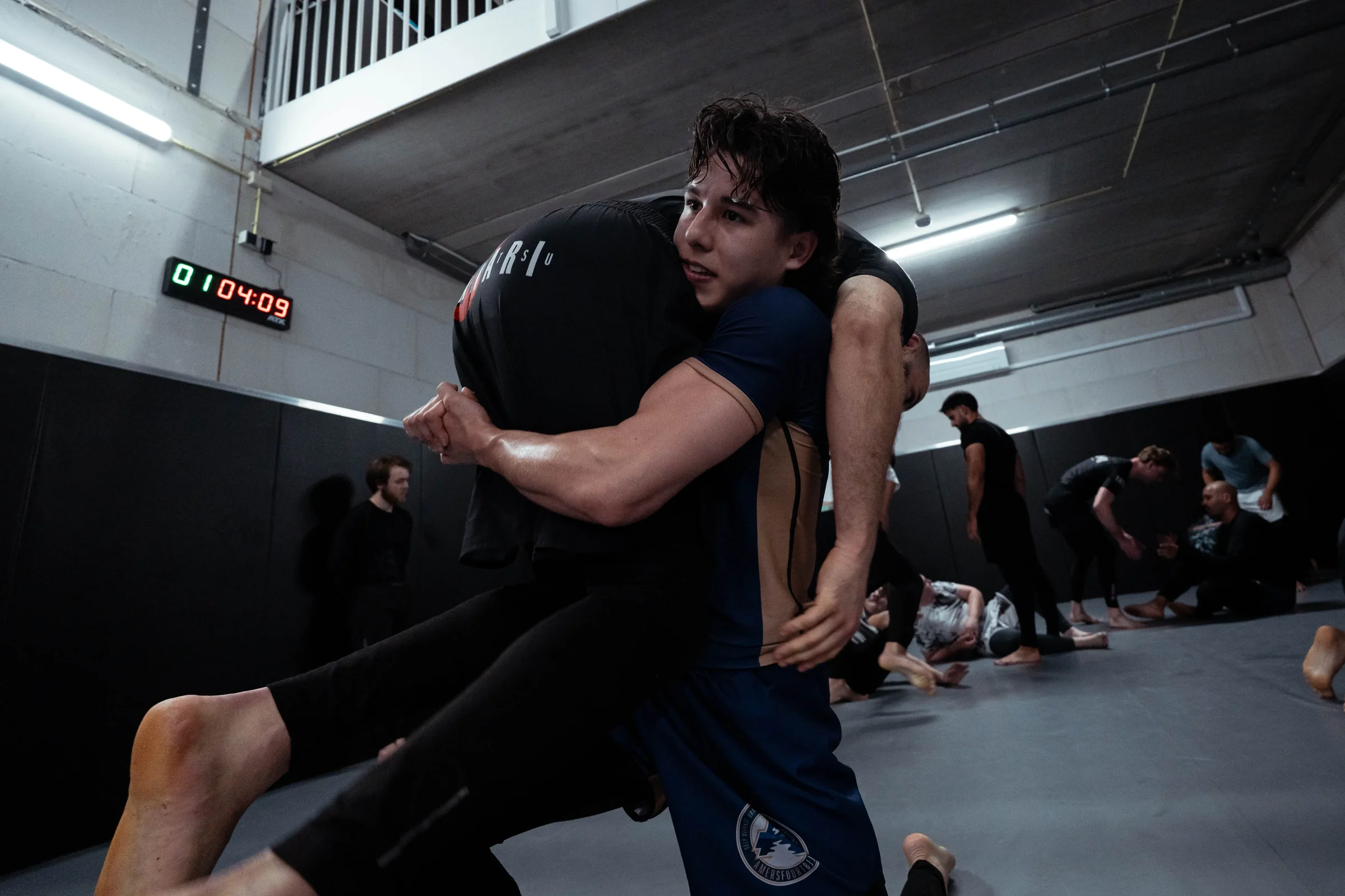 Sporter tilt zijn trainingspartner op voor een takedown tijdens de worsteltraining